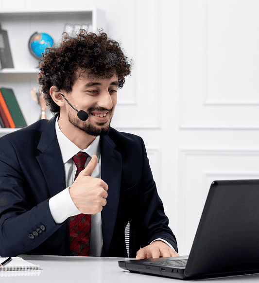 Customer service agent in a headset smiling at a laptop