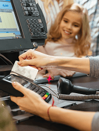 Shop assistant using a card terminal at the counter