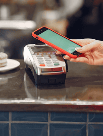 Customer paying for a latte by holding a smartphone to a reader