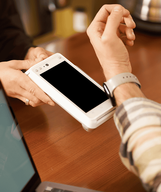 Man paying with a smartwatch in a cafe